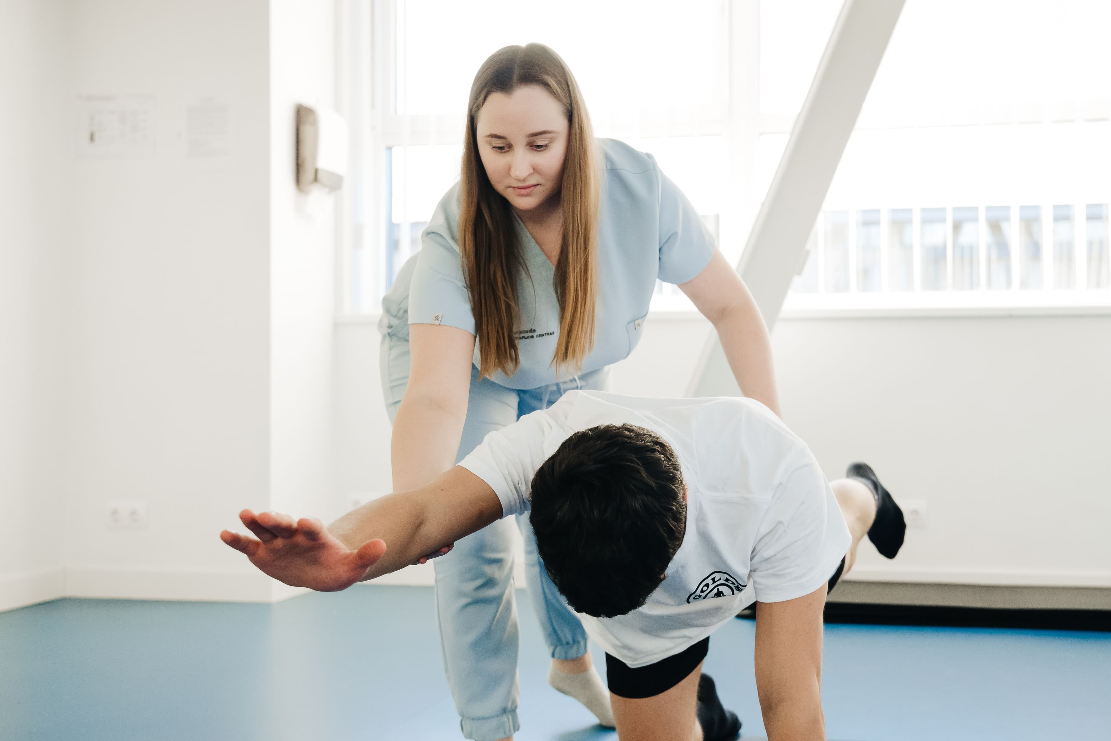 Une physiothérapeute guide une patiente dans un exercice à domicile